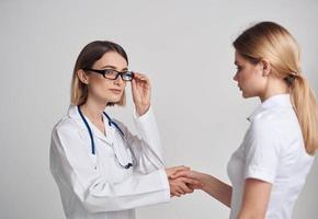 professioneel dokter vrouw en geduldig schudden handen Aan een licht achtergrond foto