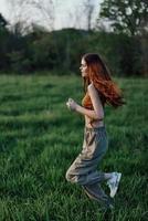 een jong vrouw oefenen buiten en rennen in de park. in de avond Aan de groen gras in de zonsondergang foto