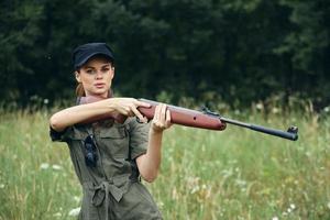vrouw soldaat op zoek verder wapens in de handen van toerisme groen overall foto