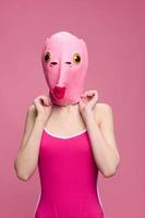 heel vreemd vrouw in een roze siliconen vis masker voor halloween, gek beeld in roze kleren foto