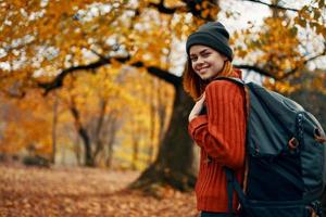 gelukkig vrouw met rugzak wandelen in park in natuur in herfst bijgesneden visie foto