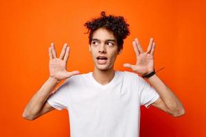 knap Mens wit t-shirt hand- gebaren emoties oranje achtergrond foto