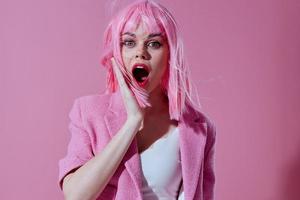 jong vrouw roze jasje Holding haar- schoonheidsmiddelen roze achtergrond ongewijzigd foto