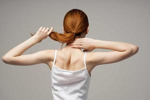 vrouw in wit t-shirt pijn in de nek artritis chronisch ziekte studio behandeling foto