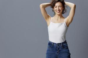 grappig gekruld mooi vrouw in eenvoudig wit t-shirt verhogen haar- stokjes tong uit poseren geïsoleerd Aan over- grijs blauw achtergrond. mensen levensstijl emoties concept. kopiëren ruimte vrij plaats aanbod foto