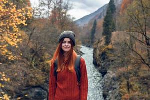 mooi vrouw wandelaar in herfst kleren in de bergen in de buurt de rivier- natuur foto