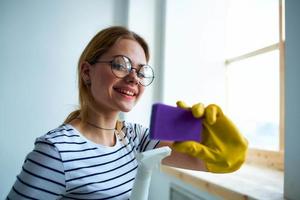 schoonmaak dame met een spons in haar handen huis zorg onderhoud wasmiddel venster schoonmaak foto