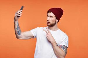 Mens met een telefoon in zijn handen modieus hoed poseren studio foto
