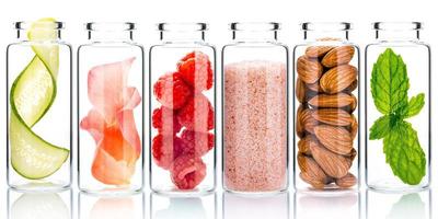 zelfgemaakte huidverzorging met natuurlijke ingrediënten en kruiden in glazen flessen geïsoleerd op een witte achtergrond foto