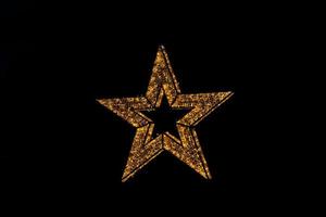 gouden decoratie schijnend ster Kerstmis decoratie Aan zwart achtergrond foto