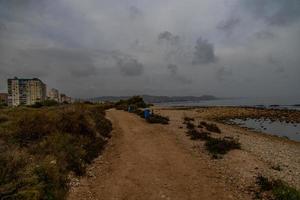 landschap leeg rotsachtig strand Aan een bewolkt dag Spanje foto