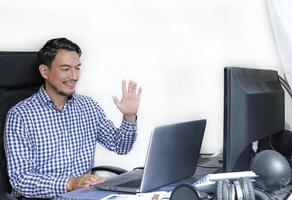 een Mens in een gecontroleerd overhemd werken van huis Bij een bureau foto