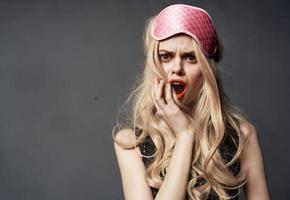 blond vrouw met roze masker voor slaap alcoholisme Gezondheid problemen model- foto