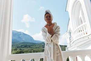 portret van prachtig vrouw staand Aan de balkon op zoek Bij de bergen vakantie in de bergen in zomer foto