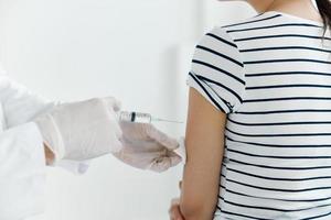 dokter met medisch handschoenen injecteert de vaccin in de patiënten hand- detailopname foto