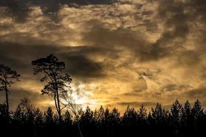 zonsondergang over- de duinen door de Baltisch zee Aan een ijzig winter dag met wolken foto