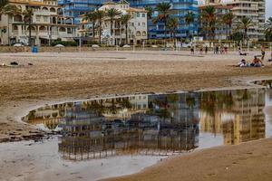 landschap breed zanderig strand in Alicante herfst dag wolken foto