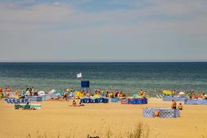 visie van de steile helling naar de strand Aan de Baltisch zee Aan een zomer dag met mensen foto