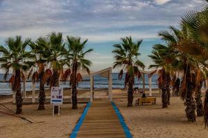 strand in Alicante playa del postiguet Spanje pad en palm bomen Aan een zonnig dag foto