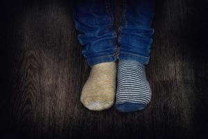 twee jongens voeten gekleed in divers gestreept sokken Aan een houten verdieping foto