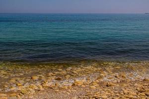 kalmte teder achtergrond van blauw zee en kust met beige stenen foto