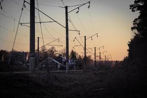 zonsondergang achter de spoorweg lijnen de licht van de instelling zon foto