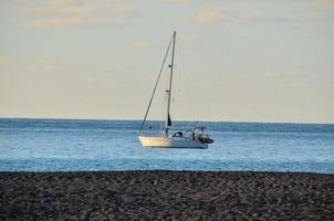 het zeilen jacht door de kust foto