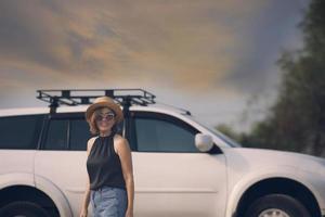 mooi vrouw staand in voorkant van suv auto met toothy glimlachen geluk gezicht foto