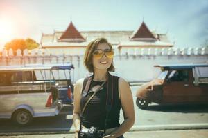 Aziatisch vrouw met dslr camera in hand- staand vooraan van tempel in ayutthaya wereld erfgoed plaats van UNESCO centraal van Thailand foto