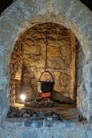 antiek keuken haard in een historisch kasteel met een metaal pot foto