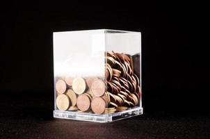 glas met munten Aan zwart achtergrond foto
