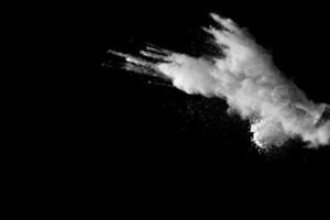 wit talk poeder explosie Aan zwart achtergrond. wit stof deeltjes plons. foto