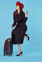 vrouw in zwart jas koffer paspoort en vlak ticket reizen foto