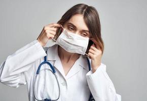 gelukkig vrouw dokter in medisch masker met stethoscoop Aan nek foto