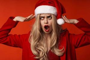 vrouw vervelend Kerstmis kleren pret vakantie poseren rood achtergrond foto