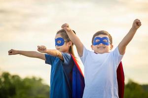 superhelden kinderen vrienden hebben pret buitenshuis, broer en zus spelen buitenshuis, jongen en meisje spelen buitenshuis foto