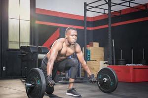 fitness man tillen gewichten in sportschool fitness, gespierde man trainen in sportschool oefeningen doen met barbell gewicht foto