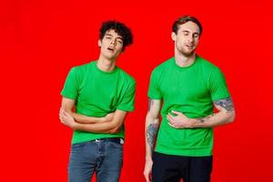 twee vrienden in groen t-shirts houden hun buik emoties foto