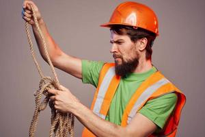 Mens in bouw uniform oranje moeilijk hoed bijgesneden visie over- beige achtergrond foto