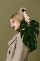 blond vrouw rood lippen palm blad charme mode groen achtergrond foto