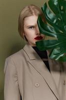 blond vrouw rood lippen palm blad charme mode studio model- ongewijzigd foto