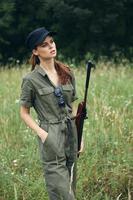vrouw Aan buitenshuis natuur reizen wapens in de handen van jacht- groen bladeren foto