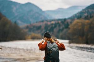 jong vrouw Aan de rivier- bank met rugzak toerisme model- reizen bergen foto