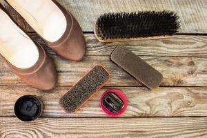 vrouwen schoenen en zorg producten voor schoenen Aan houten achtergrond. foto