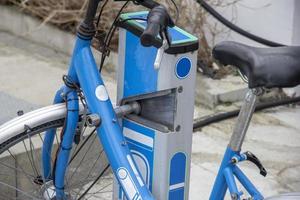 fiets sharing station. modern blauw Fietsen Bij stad verhuur station Aan zonnig dag foto