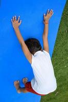 Aziatisch slim kind aan het doen yoga houding in de maatschappij park buitenshuis, kinderen yoga houding. de weinig jongen aan het doen yoga oefening. foto