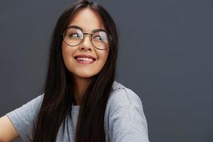 brunette bril Aan gezicht mode levensstijl grijs t-shirt studio model- foto