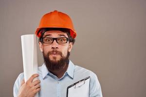 mannetje ingenieur met bril in oranje verf. professioneel blauwdrukken in handen foto