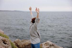 portret van een vrouw vrijheid wandelen Aan de steen kust vrouw ontspannende foto