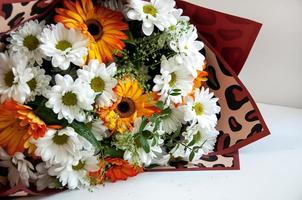 foto van een boeket van oranje en wit bloemen Aan een wit achtergrond